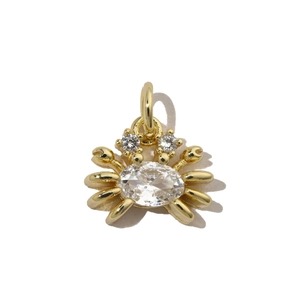 Detailed macro shot of a gold crab charm inlaid with sparkling white cubic zirconia stones