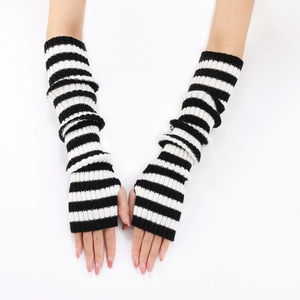 Detail shot of black and white striped knitted arm warmers on model's arms in studio light