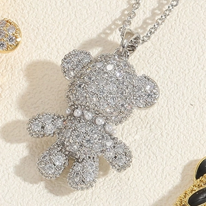 Macro shot of silver bear pendant necklace with sparkling cubic zirconia and pearl collar