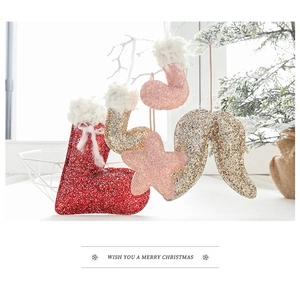 Close-up of glittery Christmas stocking and star ornaments with festive decorations