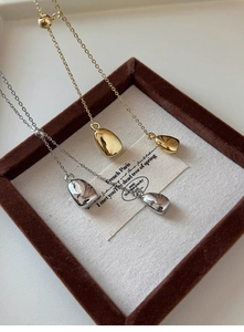 Detail of 18k gold and silver plated pebble pendant necklaces with adjustable O-chains