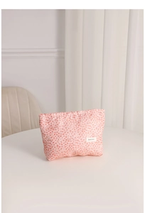 Detailed macro view of pink bubble texture fabric and woven logo on the portable travel bag