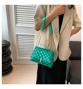 Detail of green quilted metallic chain bag with gold twist lock and fine stitching