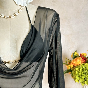Detail of black mesh swim cover-up with gold chain and pearl neckline on a mannequin