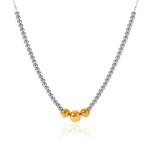 Detail of silver beaded necklace with gold accents and elegant Y-shaped tassel drop