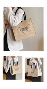 Detail view of large linen tote bag with artistic cat graphic and black shoulder straps