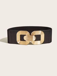 Close-up of a wide black elastic waist belt for women with a polished gold metal buckle