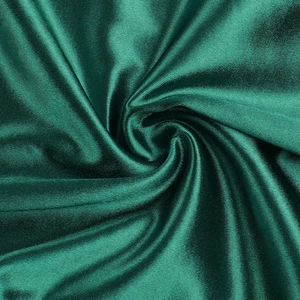 Makroaufnahme von dunkelgrünem Satinstoff mit seidiger Textur und elegantem Glanz