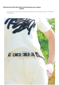 Detail of brown leather belt with silver flower rivets and buckle on light denim jeans