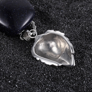 Close-up of lion heart pendant with shimmering blue stone on black sand background