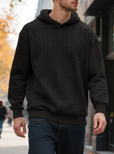 Gros plan sur la maille torsadée noire et la texture épaisse du sweat à capuche
