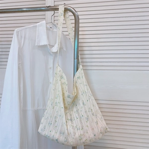Detailed texture of cotton lace tote bag with blue floral print on off-white fabric
