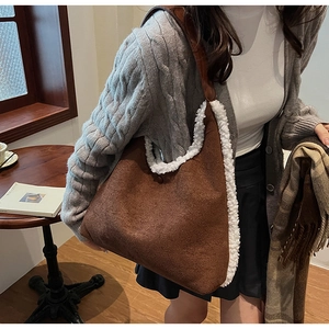 Detail of plush suede shoulder bag with soft white fur trim in a cozy cafe setting