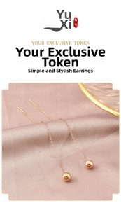 Detailed view of elegant gold ball threader earrings on a soft purple silk background