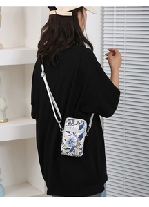Detailed side view of floral oxford cloth crossbody phone bag with white shoulder strap