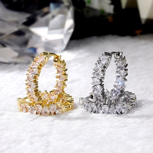 Detail of luxury gold and silver hoop earrings with pear-cut cubic zirconia stones