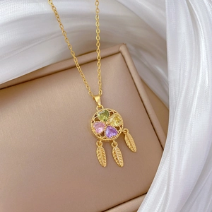 Golden dreamcatcher necklace with colorful heart gems and feathers on jewelry box