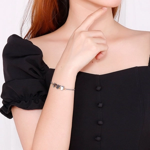 Adjustable silver tulip bracelet featuring three black and white enamel flower charms