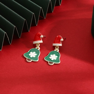 Detailed view of Christmas earrings with Santa hat and snowflake bell in festive red and green