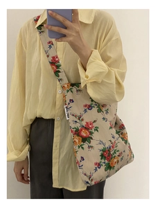 Detailed close-up of a floral canvas tote bag with vibrant red and yellow flower patterns