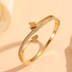 Detail of gold-plated double-layer butterfly bracelet with sparkling zircon stones