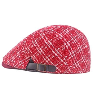 Dettaglio della trama in tweed a quadri rossi con cinturino in pelle e fibbia in metallo