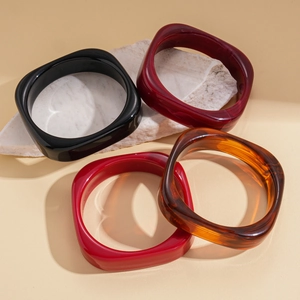 Set of four geometric resin bangle bracelets in black, red, and tortoise shell finish