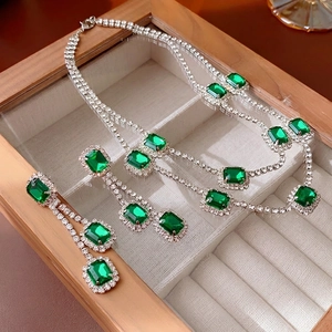 Vintage silver jewelry set featuring emerald green rectangle stones and halo diamonds