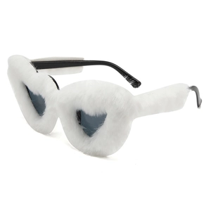 Dettaglio di occhiali da sole a cuore con montatura in morbido peluche bianco e nero