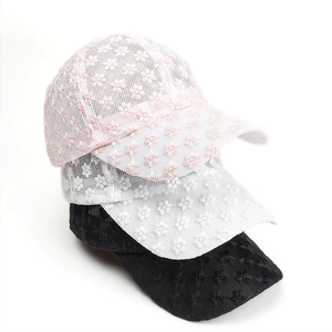 Three stacked lace baseball caps in pink, white, and black with floral embroidery detail