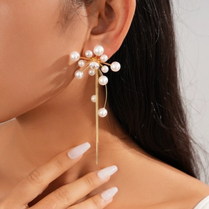 Detail of long floral tassel earrings with pearls and zircons worn by a model