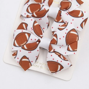 Macro detail of football print ribbon hair bows with red dots on a display card