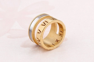 Detailed close-up of gold double-layer ring with Roman numerals and white shell inlay