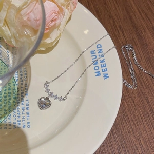 Elegant silver heart necklace with zircon pendant on a French style aesthetic table