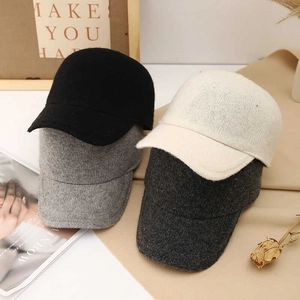 Wool blend baseball caps in four colors arranged with warm home decor aesthetic