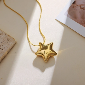 Close-up of a polished gold star pendant on a sleek snake chain necklace for women
