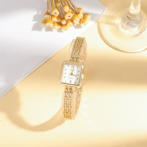 Macro shot of stylish gold rectangular quartz watch and luxury multi-link chain strap