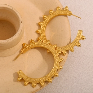 Macro detail of 18K gold plated hoop earrings with wheat pattern and beaded edge texture