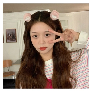 Close-up of a model wearing cute pink plush bear ear hair clips on her hair