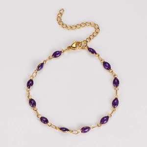 Detailed shot of golden heart bracelet with purple glitter marquise beads and lobster clasp
