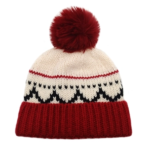 Dettaglio del berretto invernale con pompon rosso e motivo jacquard festivo
