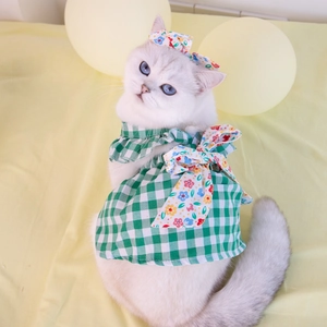 Close-up of green plaid dog dress with floral bow and matching headband set
