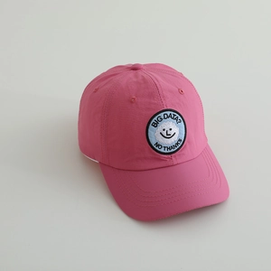 Detail der rosa Kinder-Baseballkappe mit Smiley-Wolken-Patch und Stickereilöchern