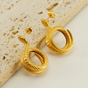 Detail of gold snake-shaped earrings showing fine scale textures and polished finish