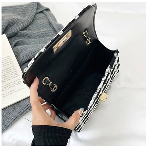 Detailed view of tweed shoulder bag interior with golden hardware and black lining