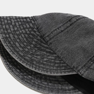 Detailed view of washed denim fabric texture and vintage stitching on a gray sun hat