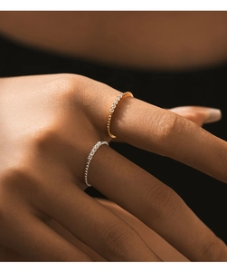 Primo piano di anelli a fascia sottile in oro e argento con micro pietre luccicanti