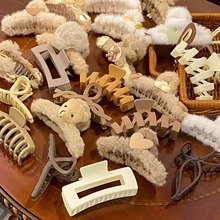 Detail view of assorted Chinese hair clips and plush bear pins on a wooden surface