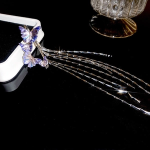 Close-up of purple and blue gradient butterfly earrings with long metallic fringe tassels