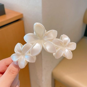 Detailed view of elegant pearlescent lily hair claw clip with triple flower design